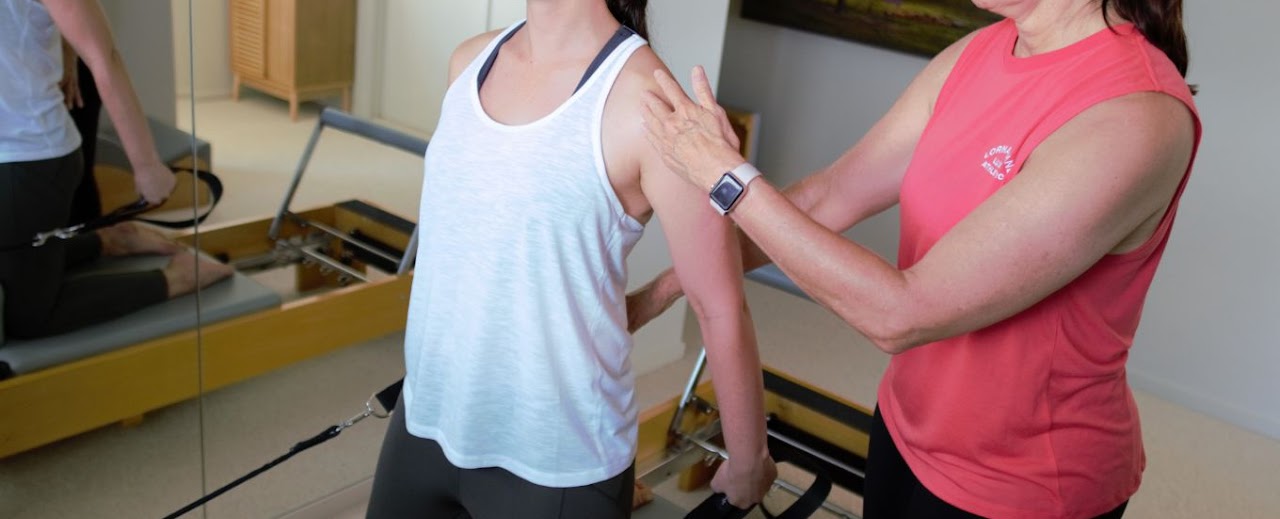 Pilates teacher and female exercising on the Pilates reformer in Kingscliff Studio